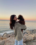 Susan H. holding her dog at the beach