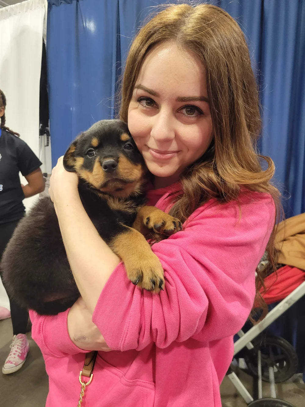 Groomer hugging a rottweiler puppy